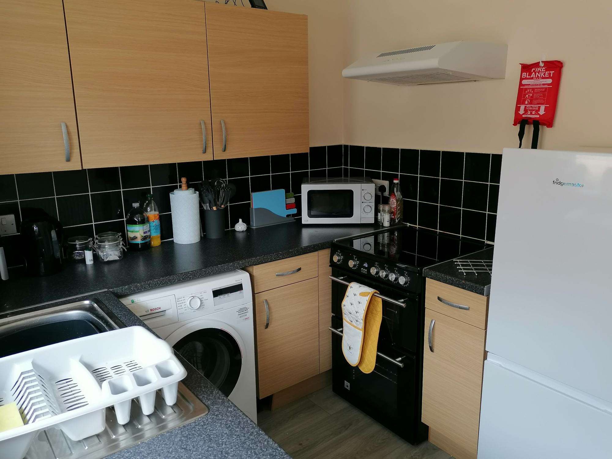 Kitchen with cupboards, cooker and fridge